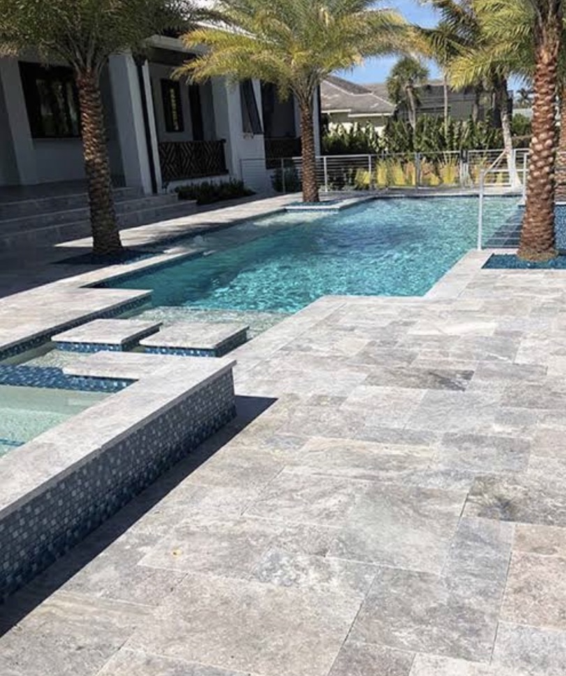 Pavé de travertin Silver autour d'une piscine, teinte grise.